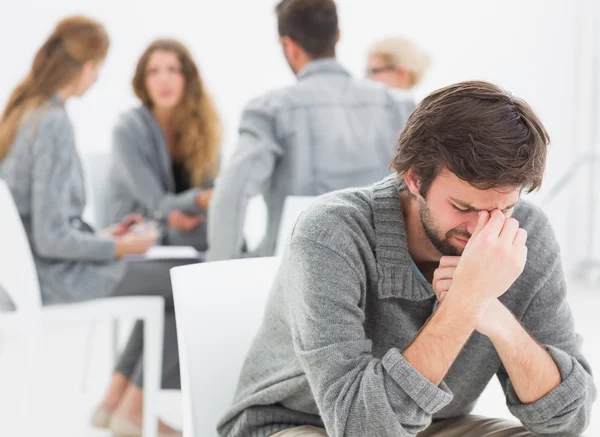 Therapy in session sitting in a circle while man in foreground — Stock Photo, Image