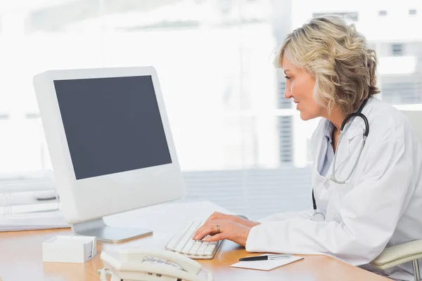 Médica usando computador em consultório médico — Fotografia de Stock