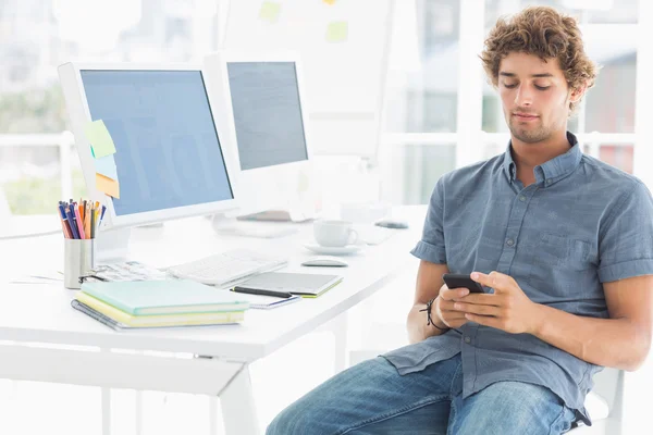 Man text messaging in a bright office — Stock Photo, Image