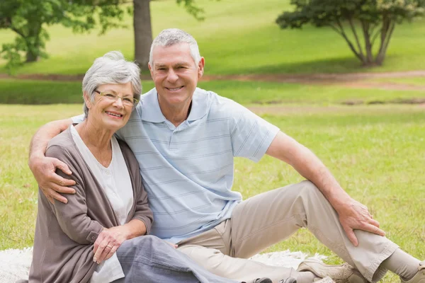 Portrait of a senior couple sitting at park — Stock Photo, Image