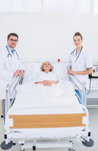 Médicos visitando uma paciente do sexo feminino no hospital — Fotografia de Stock