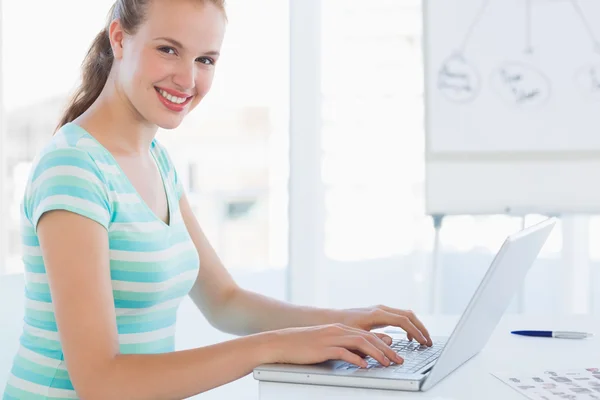 Retrato de vista lateral de uma jovem mulher casual usando laptop — Fotografia de Stock