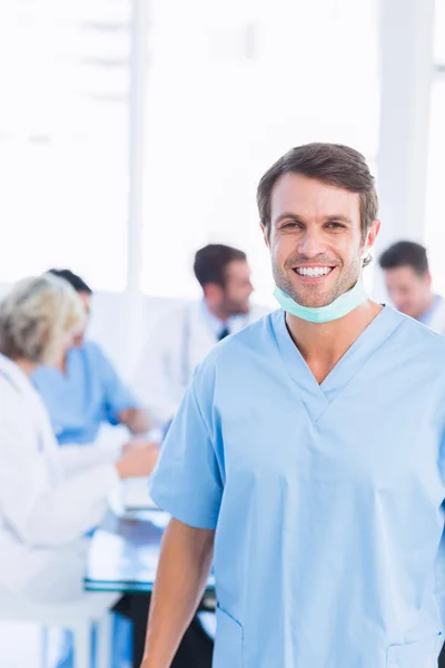 Cirurgião sorridente com colegas em reunião — Fotografia de Stock