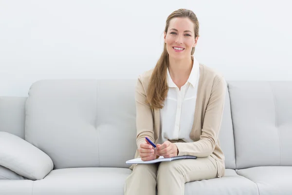 Χαμογελαστά γυναικεία οικονομικός σύμβουλος κάθεται στον καναπέ — Φωτογραφία Αρχείου