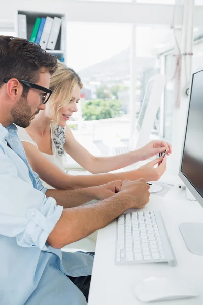 Sonriente pareja joven casual trabajando en la computadora — Foto de Stock