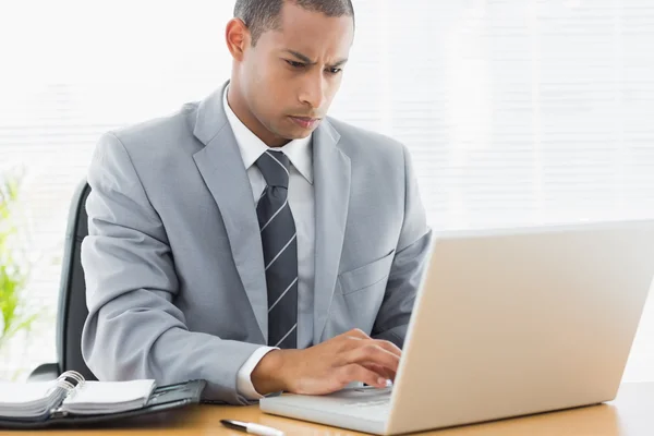 Homme d'affaires concentré utilisant un ordinateur portable au bureau — Photo