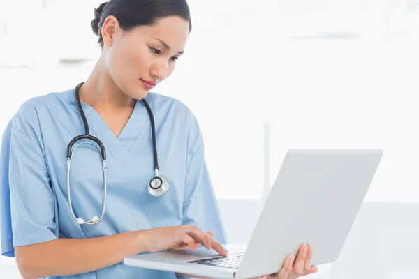 Concentrated surgeon using a laptop in hospital — Stock Photo, Image