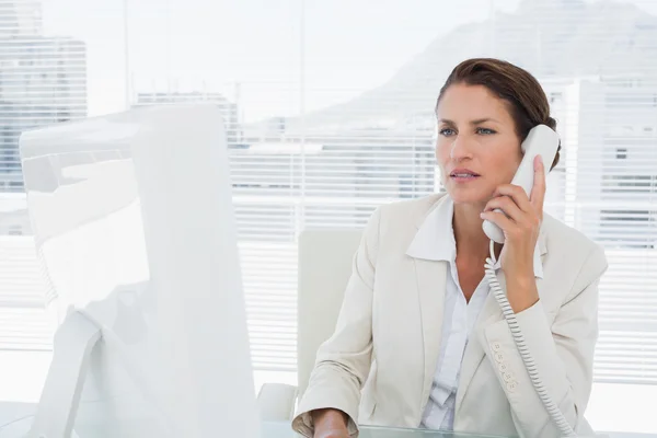 Businesswoman using computer and phone — Stock Photo, Image