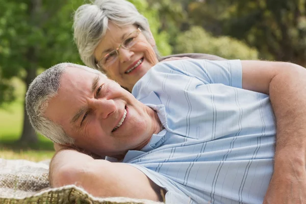 Close-up portrait of a senior couple lying at park — Stock Photo, Image