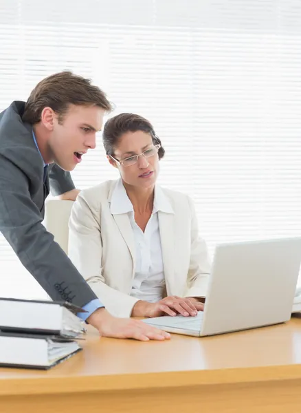 Business couple using laptop at office desk — Stock Photo, Image