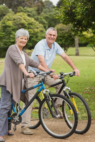 Pareja mayor en paseo en bicicleta en el campo — Foto de Stock