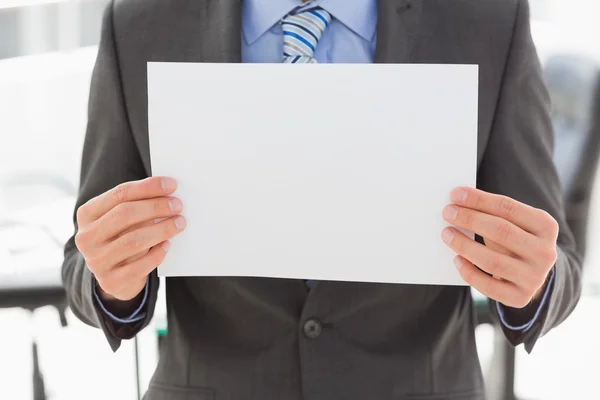 Businessman holding blank page — Stock Photo, Image