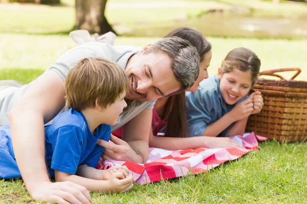 Uśmiechający się para młodych dzieci leżące w parku — Zdjęcie stockowe