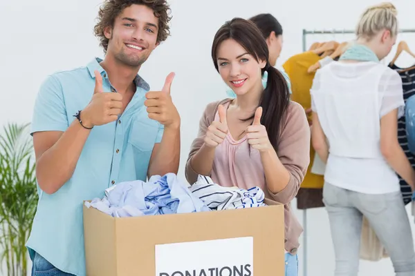 People with clothes donation gesturing thumbs up — Stock Photo, Image