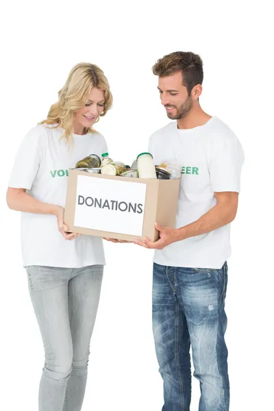 Sonriente joven pareja llevando caja de donaciones — Foto de Stock