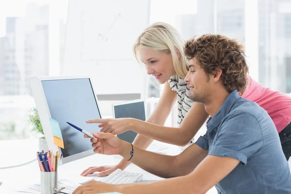 Casual couple using computer in office — Stock Photo, Image