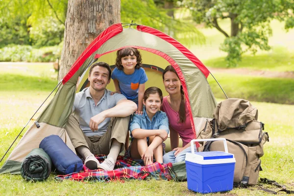 Casal com crianças sentadas na tenda no parque — Fotografia de Stock