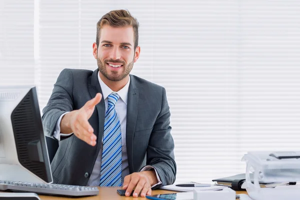 Geschäftsmann reicht Handschlag am Schreibtisch — Stockfoto