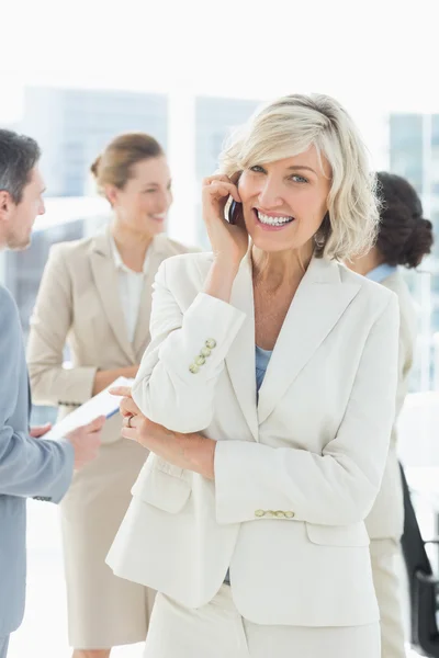 Mature businesswoman on call with colleagues discussing at offic — Stock Photo, Image