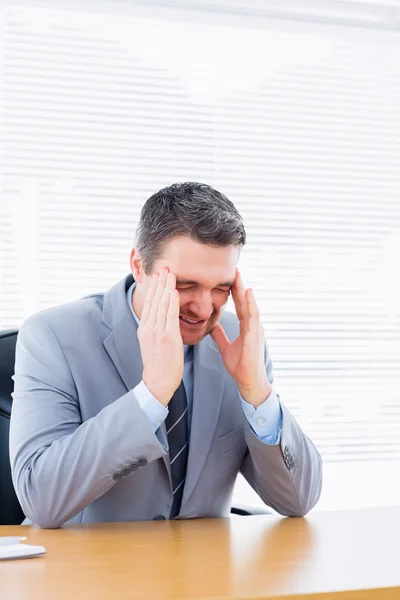 Ofis Masası, şiddetli baş ağrısı ile işadamı — Stok fotoğraf