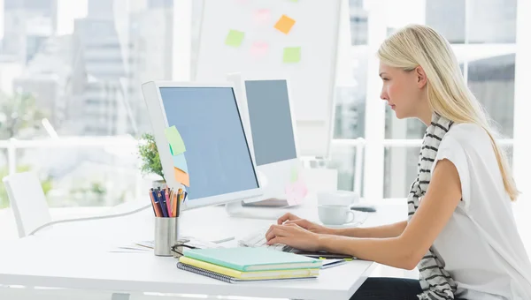 Casual jonge vrouw met behulp van de computer in kantoor — Stockfoto