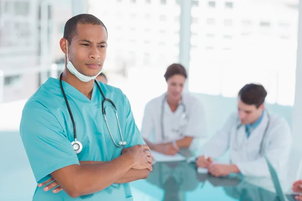 Surgeon standing with group around table in hospital — Stock Photo, Image