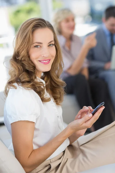 Messaggi di testo di una donna d'affari con colleghi che utilizzano laptop — Foto Stock