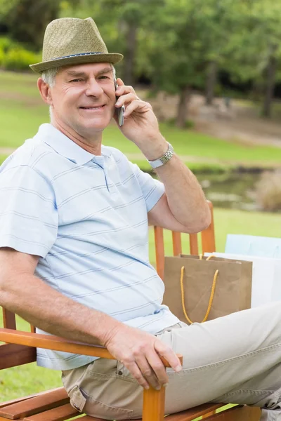 Hombre mayor relajado usando teléfono móvil en el parque —  Fotos de Stock