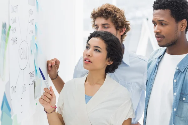 Artists in discussion in front of whiteboard — Stock Photo, Image