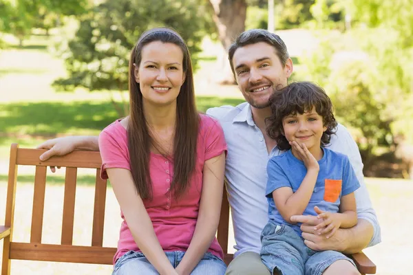 Ler par med son sitter på parkbänk — Stockfoto