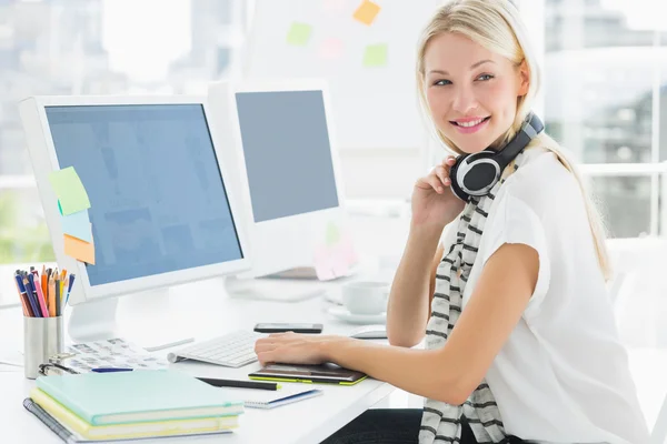 Mujer casual con auriculares en el escritorio de la computadora en la oficina —  Fotos de Stock