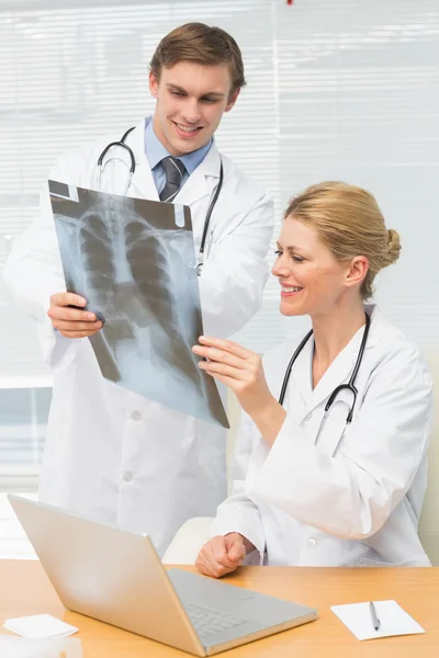 Счастливые врачи вместе осматривают рентген — стоковое фото