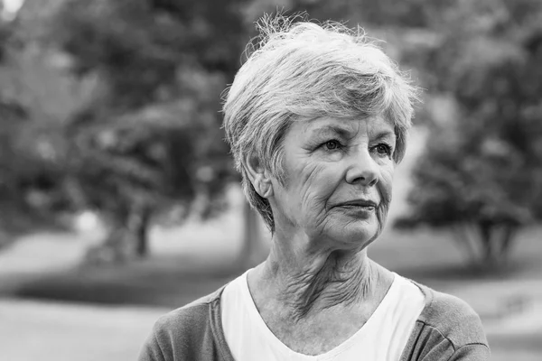 Donna anziana guardando il parco — Foto Stock