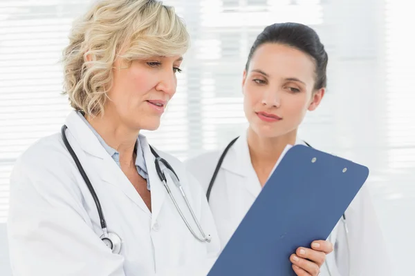 Two female doctors reading medical reports — Stock Photo, Image