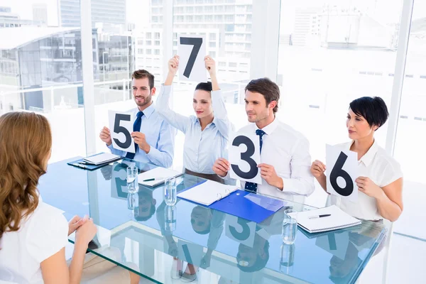 Grupo de jueces del panel con signos de puntuación delante de la mujer — Foto de Stock