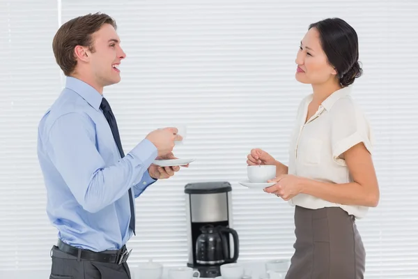 Business par med tekoppar chattar i office — Stockfoto