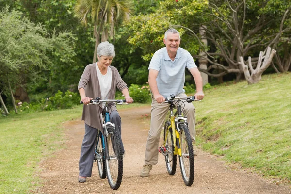 Oudere paar op de fiets rijden in het platteland — Stockfoto