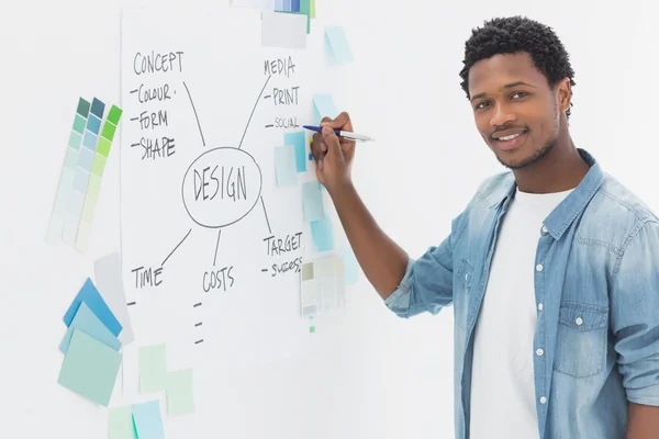 Smiling male artist with pen in front of whiteboard — Stock Photo, Image