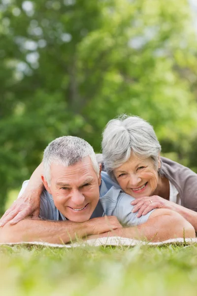 Sorridente rilassato coppia anziana sdraiata nel parco — Foto Stock