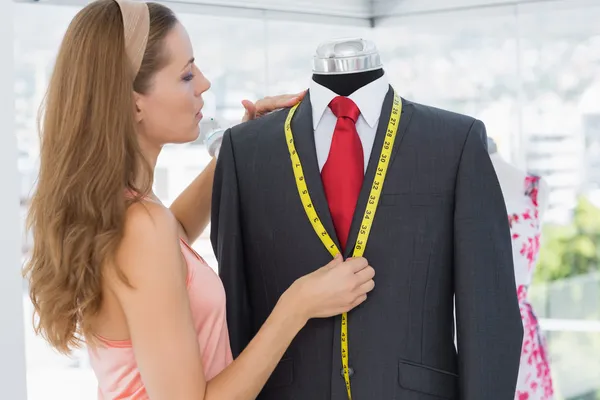 Female fashion designer measuring suit on dummy — Stock Photo, Image