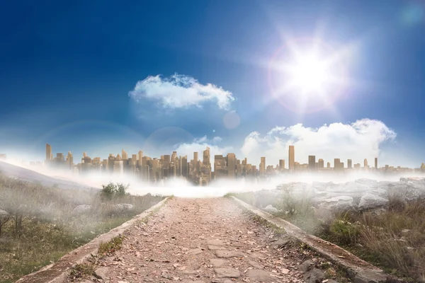 Caminho pedregoso que leva a uma grande expansão urbana sob o sol — Fotografia de Stock