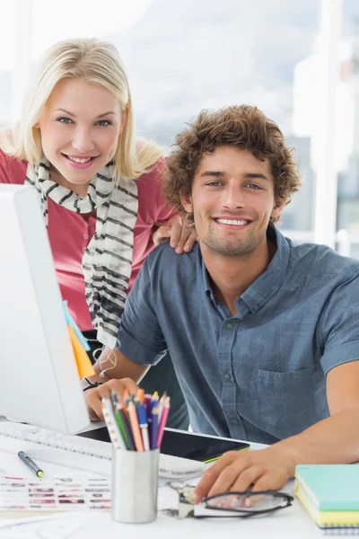 Senyum pasangan santai menggunakan komputer di kantor cerah — Stok Foto