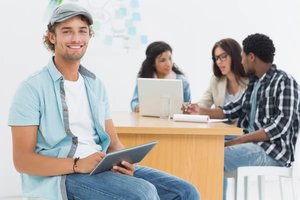 Man met digitale tablet met collega's achter in office — Stockfoto