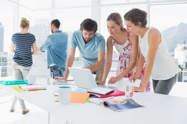 Gente de negocios casuales usando el ordenador portátil juntos — Foto de Stock