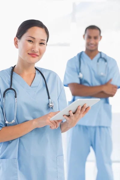 Beautiful female surgeon holding digital tablet — Stock Photo, Image