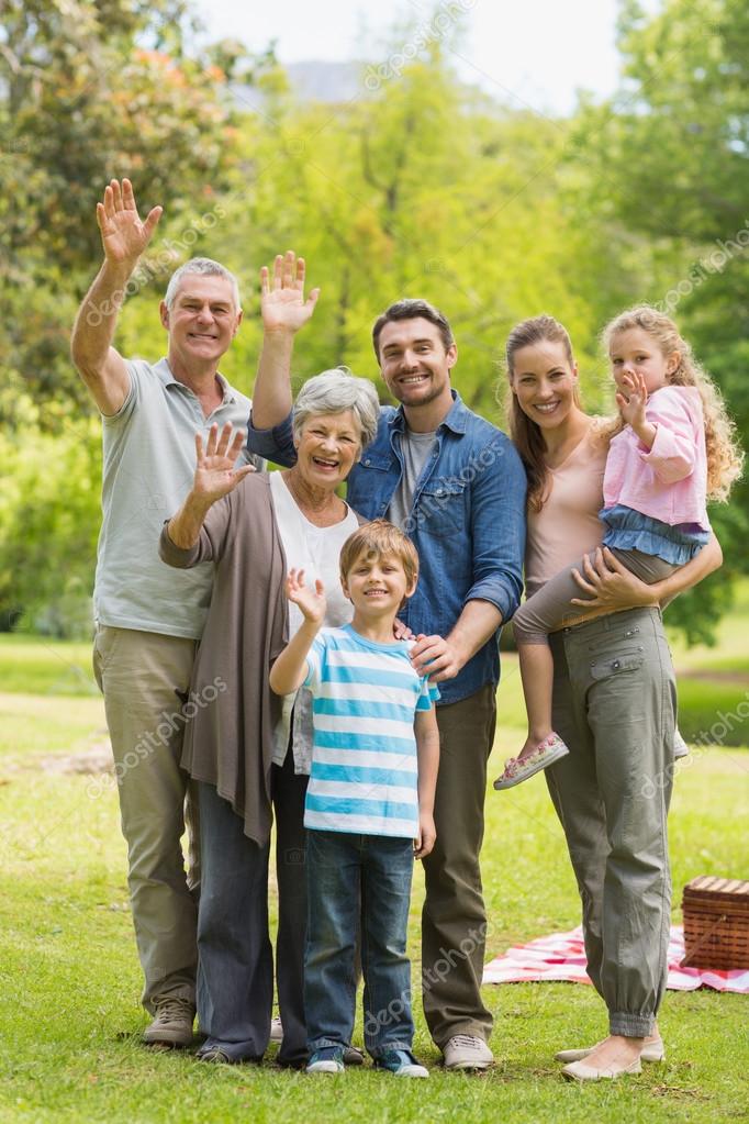 Portrait of an extended family waving hands in the park