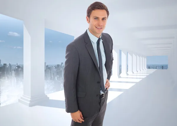 Composite image of cheerful businessman standing with hand on hi — Stock Photo, Image