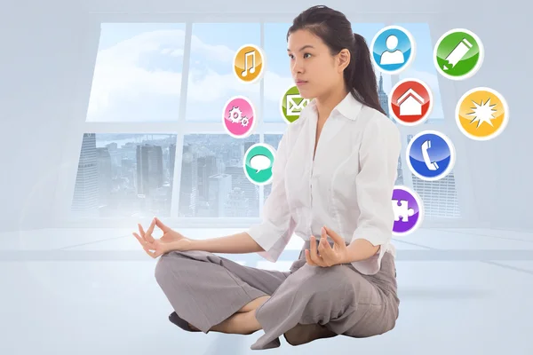 Composite image of businesswoman sitting in lotus pose — Stock Photo, Image