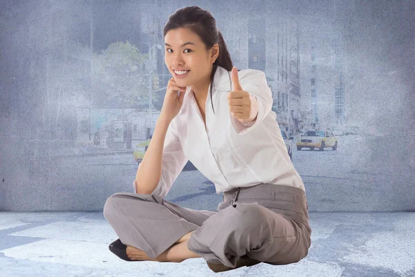 Composite image of businesswoman sitting cross legged showing th — Stock Photo, Image
