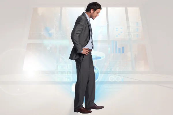 Composite image of smiling businessman with hands on hips — Stock Photo, Image